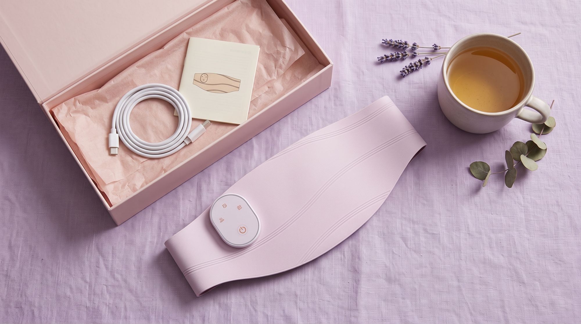 The Lunelle belt with its pink gift box, charging cable and manual
